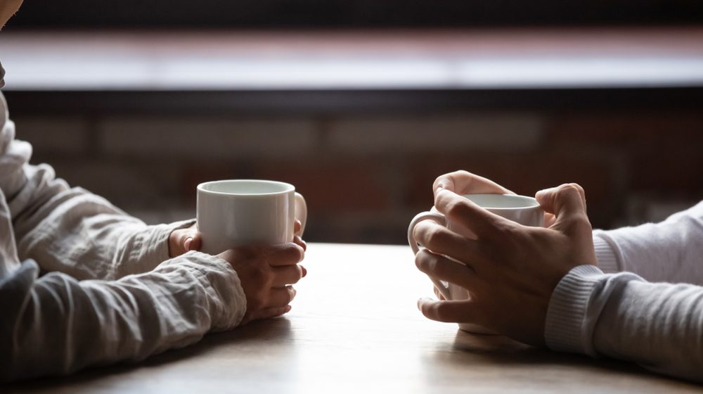 Close,Up,Woman,And,Man,Sitting,In,Cafe,,Holding,Warm